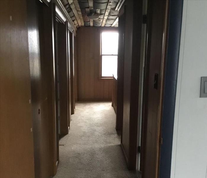 A hallway with missing ceiling tiles