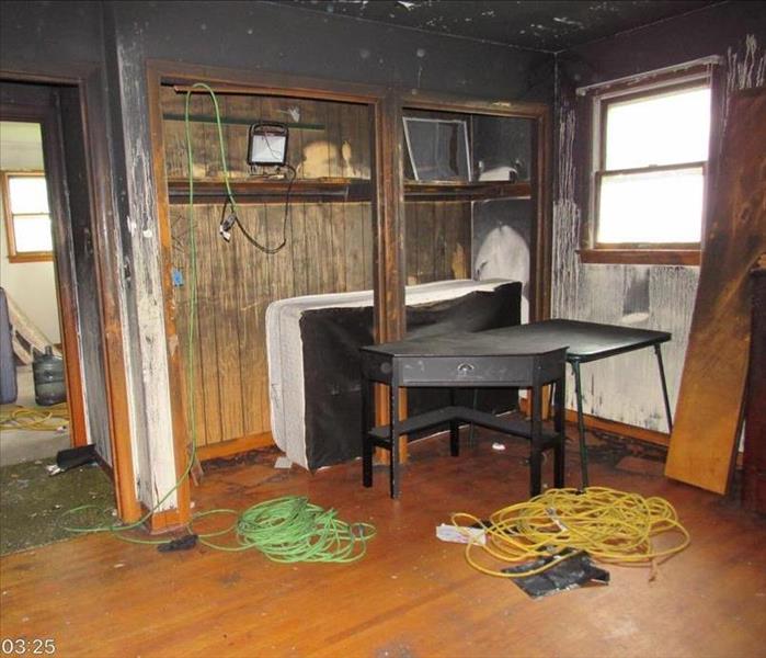 A bedroom with 2 closets soot running down the walls.