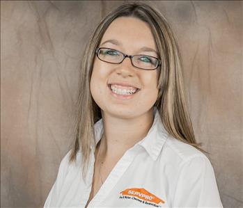 A young female with long brown and blond hair with glasses and a white shirt. 